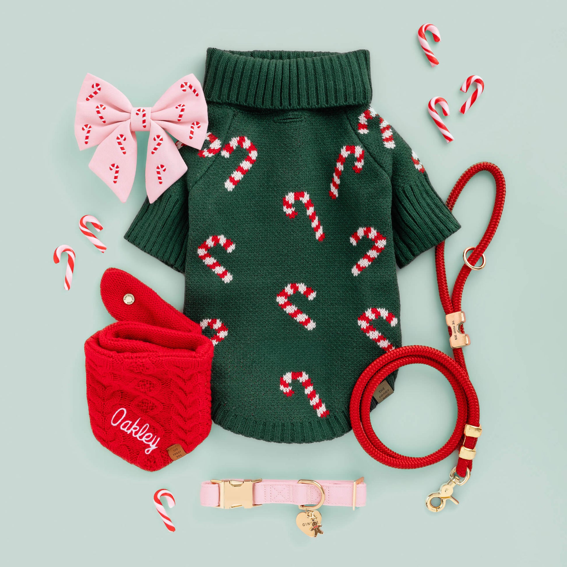 Evergreen Candy Canes Dog Sweater, Blush Pink Candy Canes Lady Bow, Ruby Marine Rope Leash, Cable Knit Bandana, Blush Pink Collar, Heart ID Tag, and Gingerbread Man Charm from The Foggy Dog